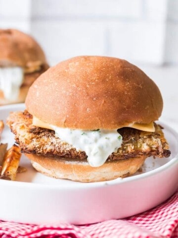 baked fish burger on white plate and red napkin