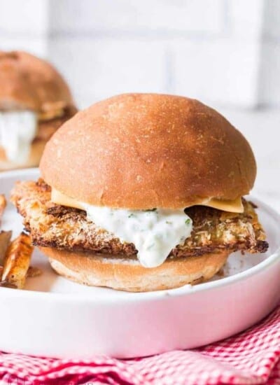 baked fish burger on white plate and red napkin