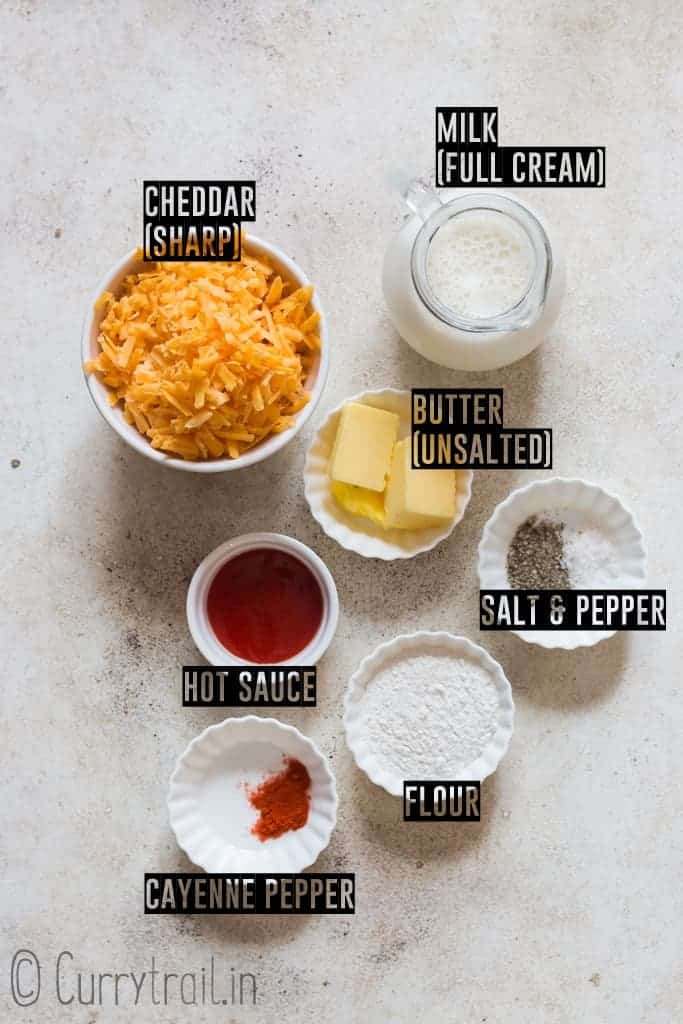 all ingredients for spicy nacho cheese sauce on white board