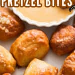 homemade soft pretzel bites on white plate with cheese sauce with text overlay