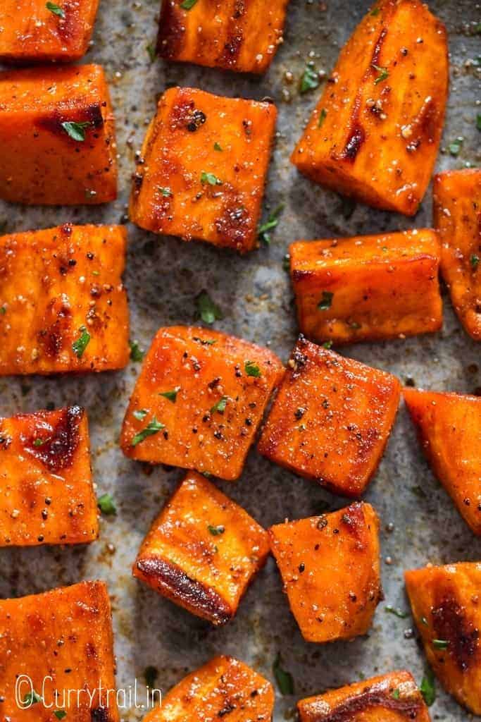 oven roasted sweet potatoes on baking tray garnished with parsley