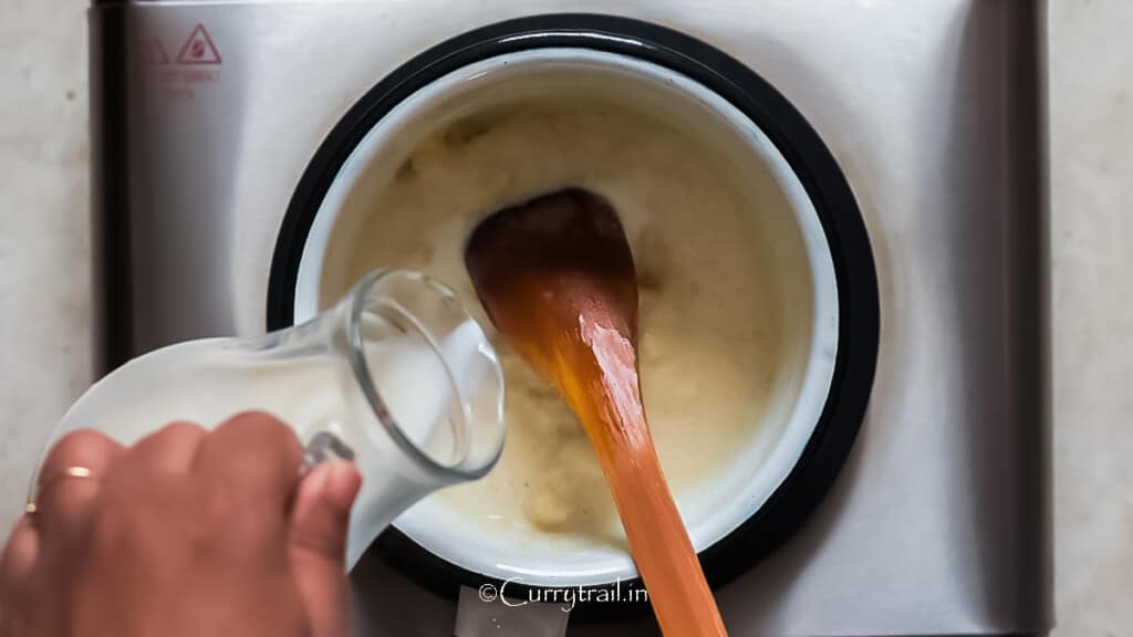 milk is added to flour mix in a saucepan to make the cheese sauce.