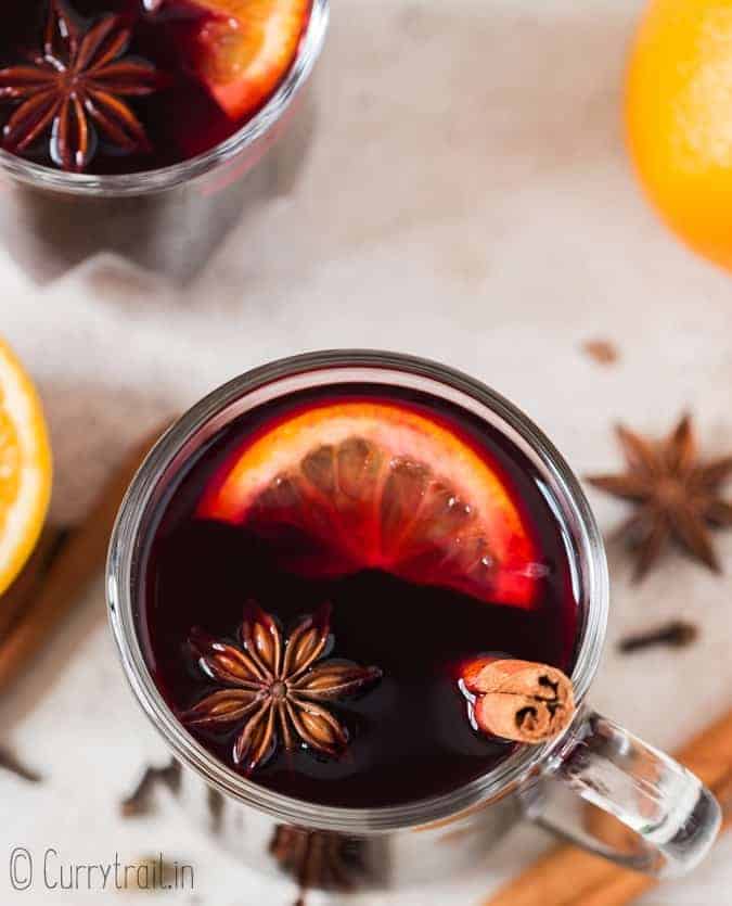 hot mulled wine in heat proof mugs with spices on sides