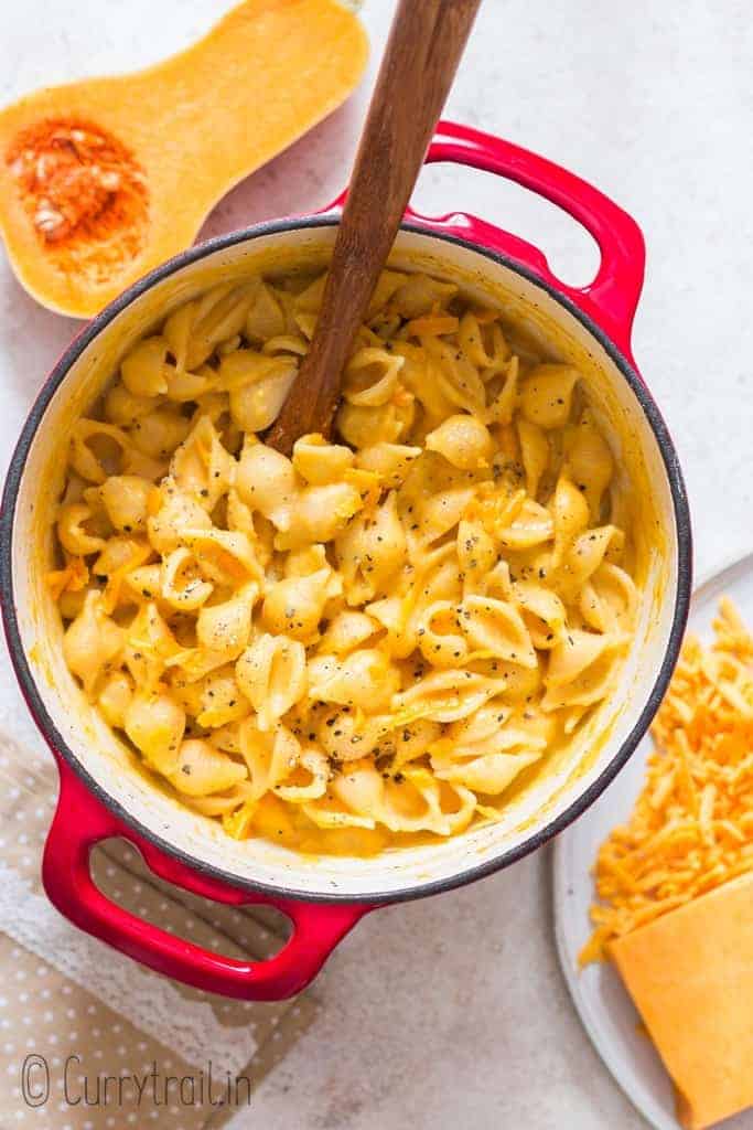 creamy butternut mac and cheese in pot with wooden spatula
