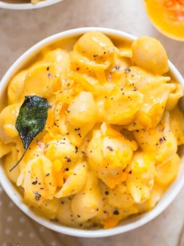 healthy squash mac and cheese with crispy sage leaves in ceramic bowl