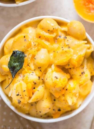 healthy squash mac and cheese with crispy sage leaves in ceramic bowl