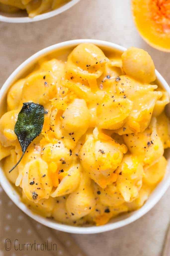 healthy squash mac and cheese with crispy sage leaves in ceramic bowl