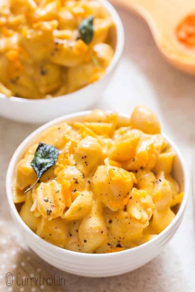 healthy squash mac and cheese with crispy sage leaves in ceramic bowl