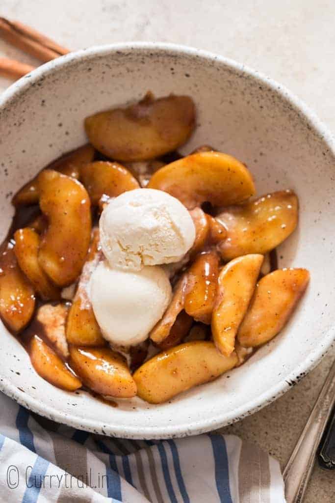 cinnamon apples with ice cream on white bowl