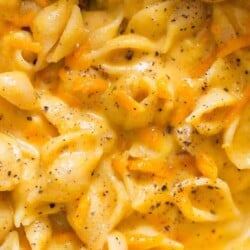 creamy butternut mac and cheese in pot with wooden spatula