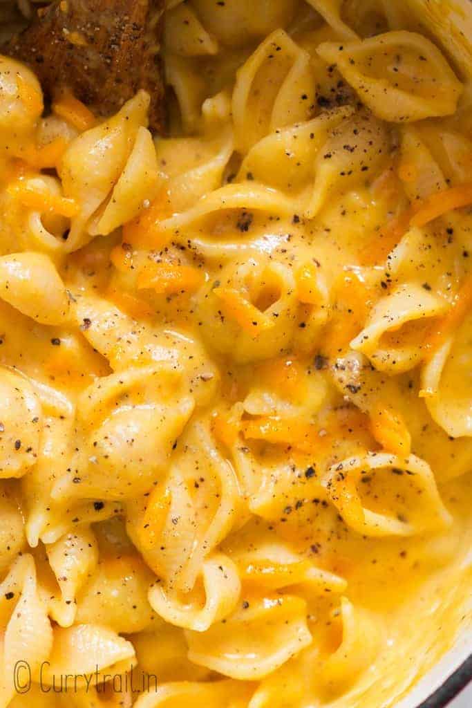 creamy butternut mac and cheese in pot with wooden spatula