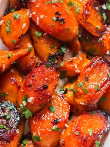 roasted glazed honey carrots with brown butter garlic in white servings dish