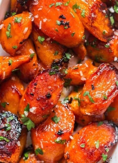 roasted glazed honey carrots with brown butter garlic in white servings dish
