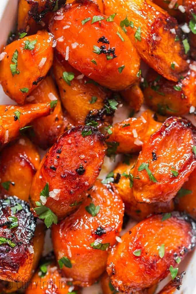 roasted glazed honey carrots with brown butter garlic in white servings dish