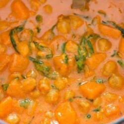 close up of thai curry with sweet potatoes and chickpeas cooked in pot