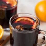 traditional mulled wine in heat proof mugs with spices on sides