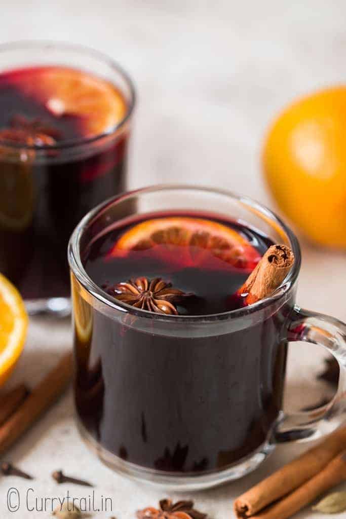 traditional mulled wine in heat proof mugs with spices on sides