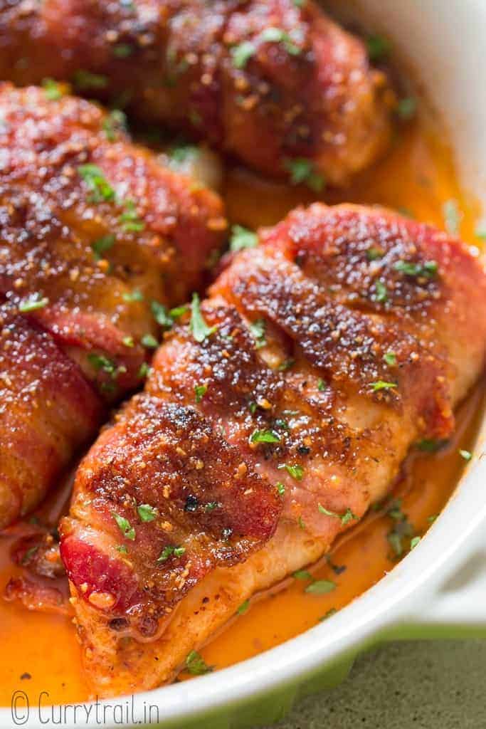 chicken breast wrapped with fatty bacon and baked until caramelized to perfection in baking dish 