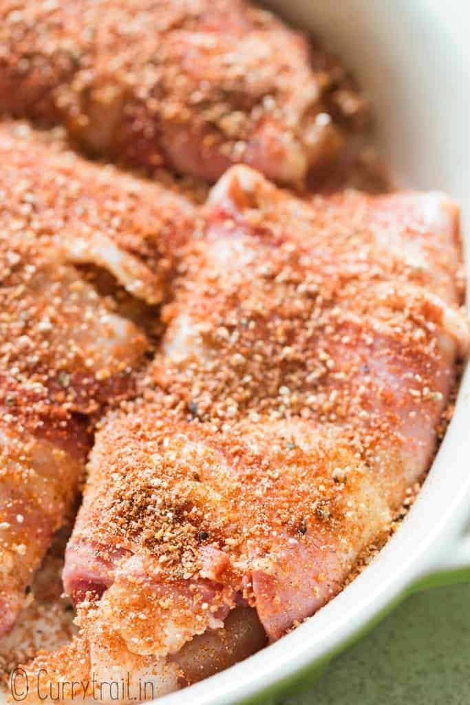 chicken breast wrapped with bacon and sprinkled with brown sugar spice mix in baking dish