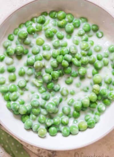 peas in white cream sauce in white ceramic bowl