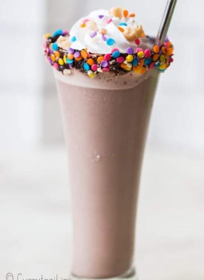 3 ingredients nutella milkshake in tall glass with whipped cream and straw