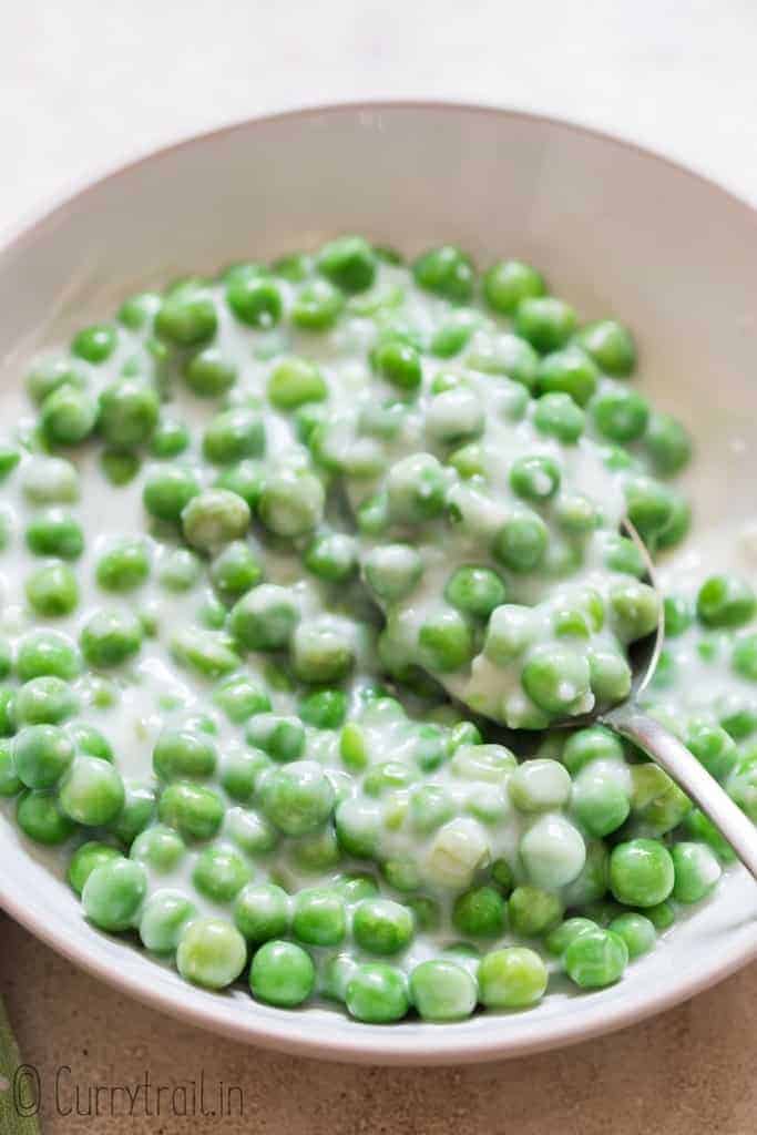 peas in white cream sauce in ceramic bowl