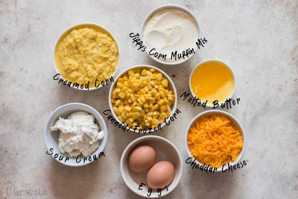 all ingredients for creamy corn casserole on white board