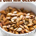 close up photo of savory roasted pumpkin seeds in ceramic bowl with text