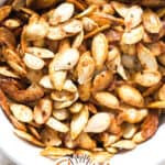 healthy crunchy roasted pumpkin seeds in ceramic bowl witht ext overlay