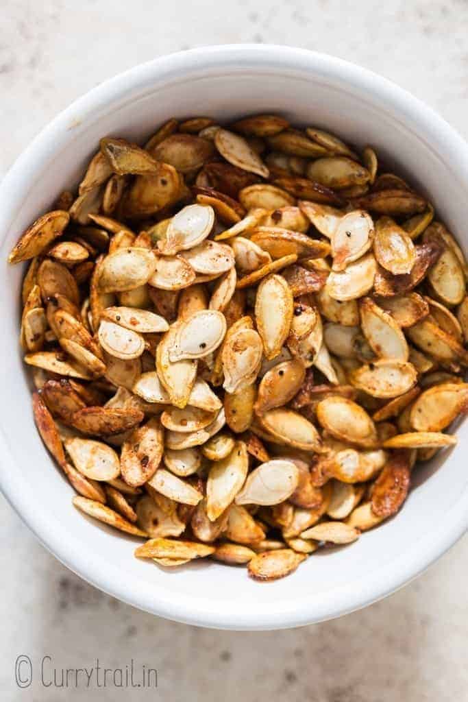 savory pumpkin seeds roasted in oven in ceramic bowl with text