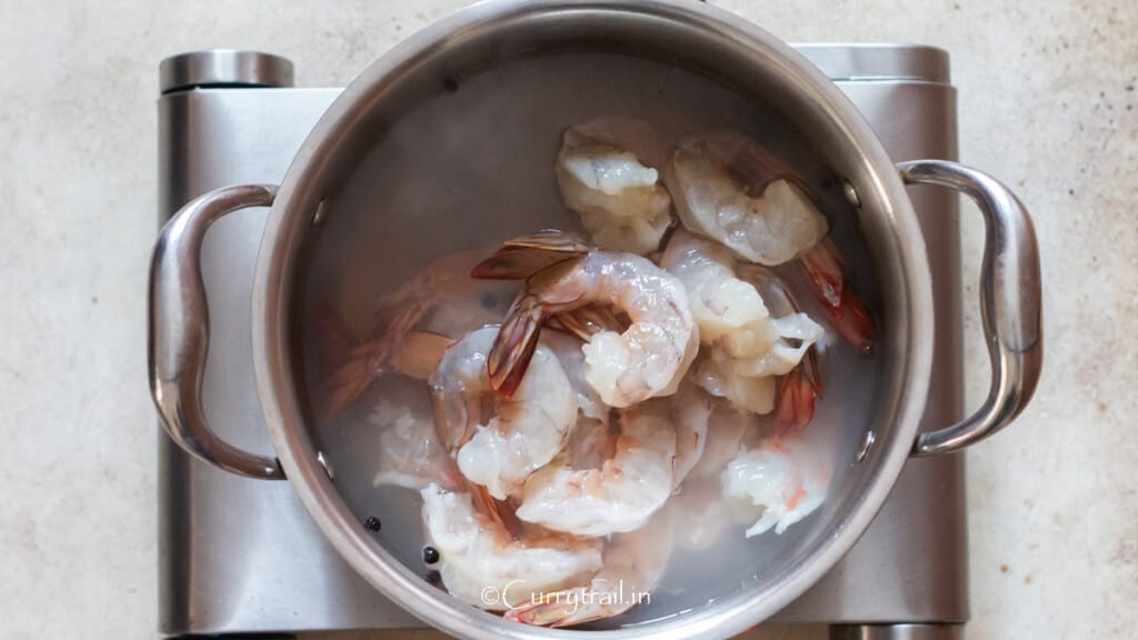blanching peeled, deveined prawns with tails on in a pot of seasoned boiling water.