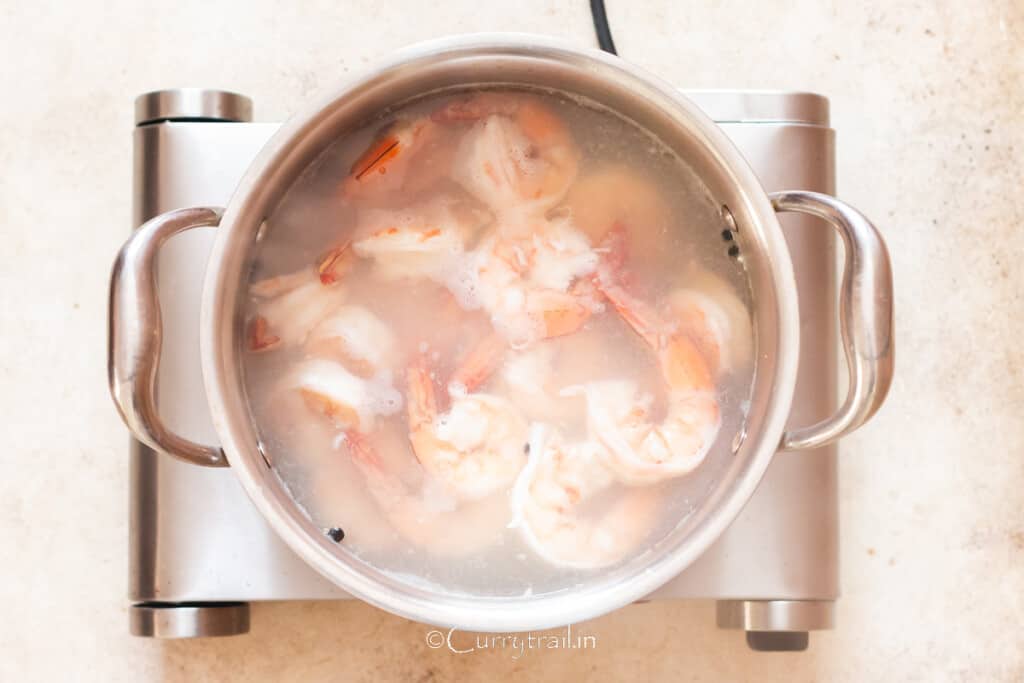 blanching peeled, deveined prawns with tails on in a pot of seasoned boiling water.