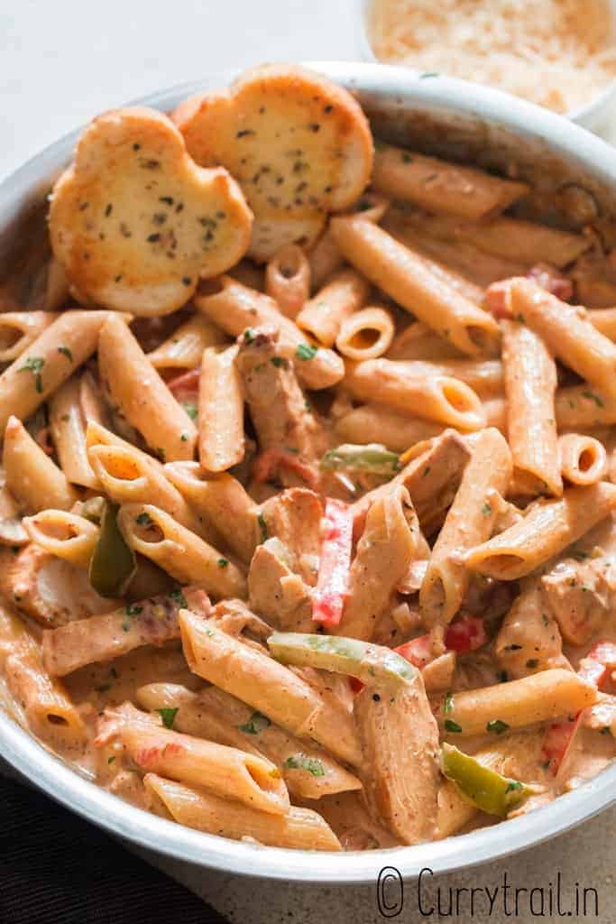 cajun creamy chicken pasta cooked in skillet served with garlic bread slices