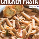 cajun creamy chicken pasta cooked in skillet served with garlic bread slices with text