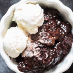 fudgy rich chocolate pudding cake in white ceramic bowl with vanilla ice cream