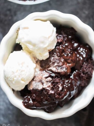 fudgy rich chocolate pudding cake in white ceramic bowl with vanilla ice cream