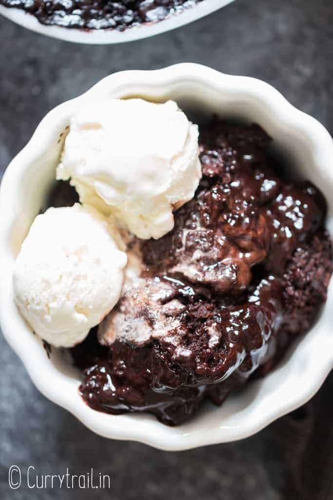 fudgy rich chocolate pudding cake in white ceramic bowl with vanilla ice cream
