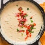 queso dip cooked in cast iron skillet with fresh pico de gallo garnish