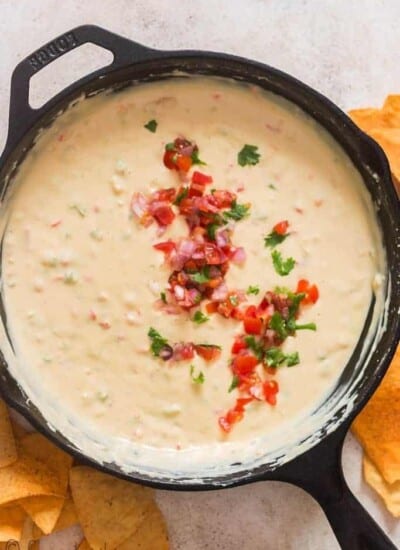 queso dip cooked in cast iron skillet with fresh pico de gallo garnish