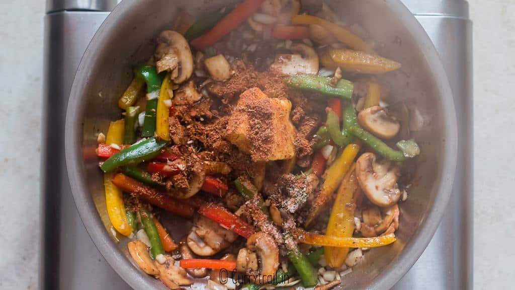 cooking veggies in skillet with spices