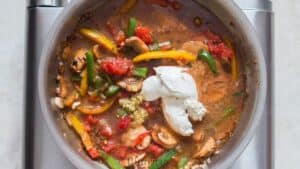 cream cheese in vegetables in skillet to make cajun chicken pasta