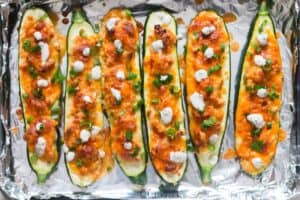 zucchini boats with green onions garnish and Ranch dressing on top