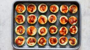 adding topping on zucchini slices for making pizza bites