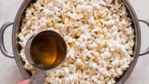 adding ghee to freshly popped popcorn