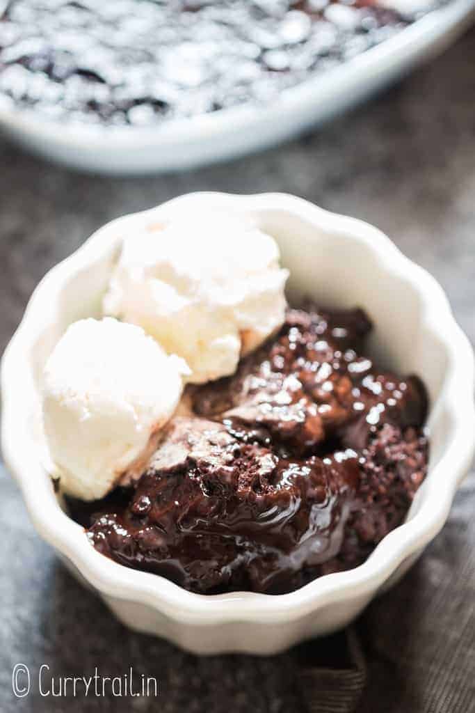 fudgy rich chocolate pudding cake in white ceramic bowl with vanilla ice cream