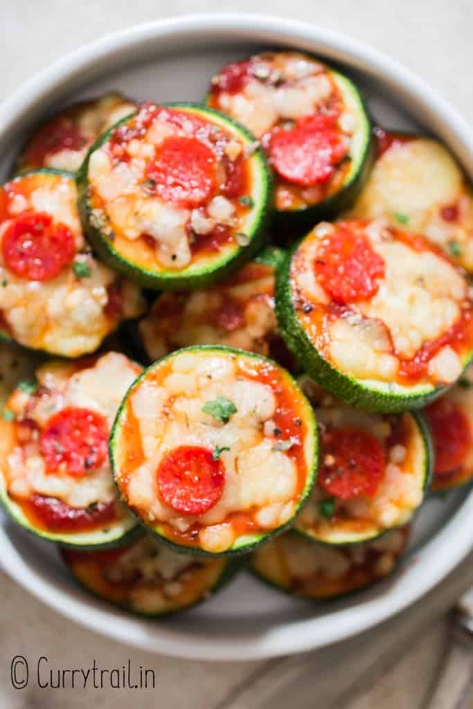 zucchini pizza bites stacked up in ceramic plate