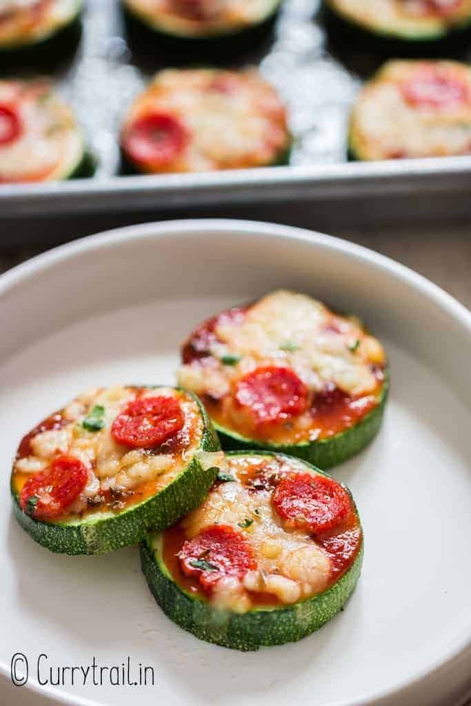 three zucchini pizza bites on white ceramic plate