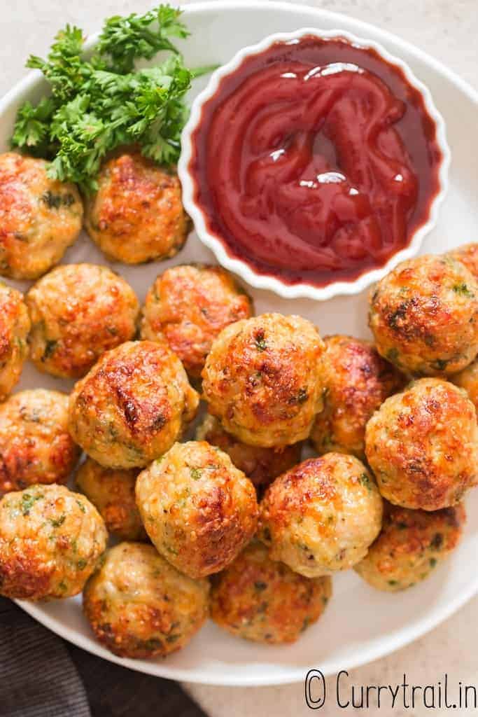 easy baked chicken meatballs stacked in plate served with ketchup