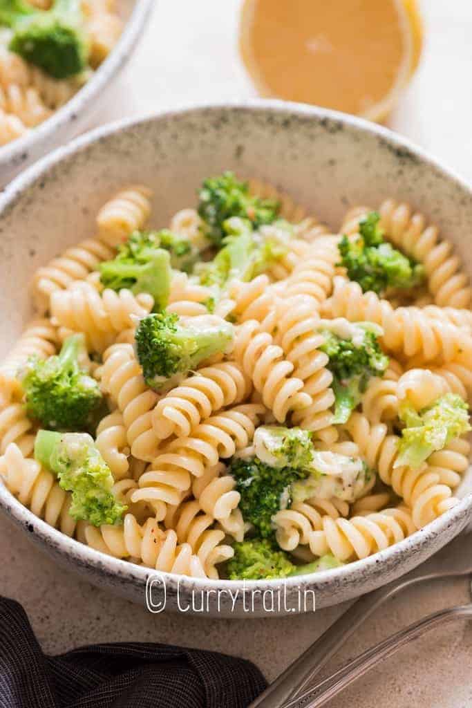 broccoli fusilli pasta served in ceramic bowl with lemon on side