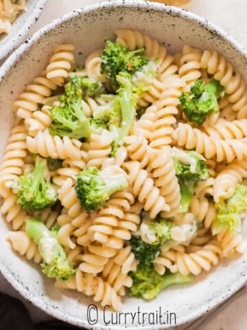 broccoli fusilli pasta served in ceramic bowl with lemon on side